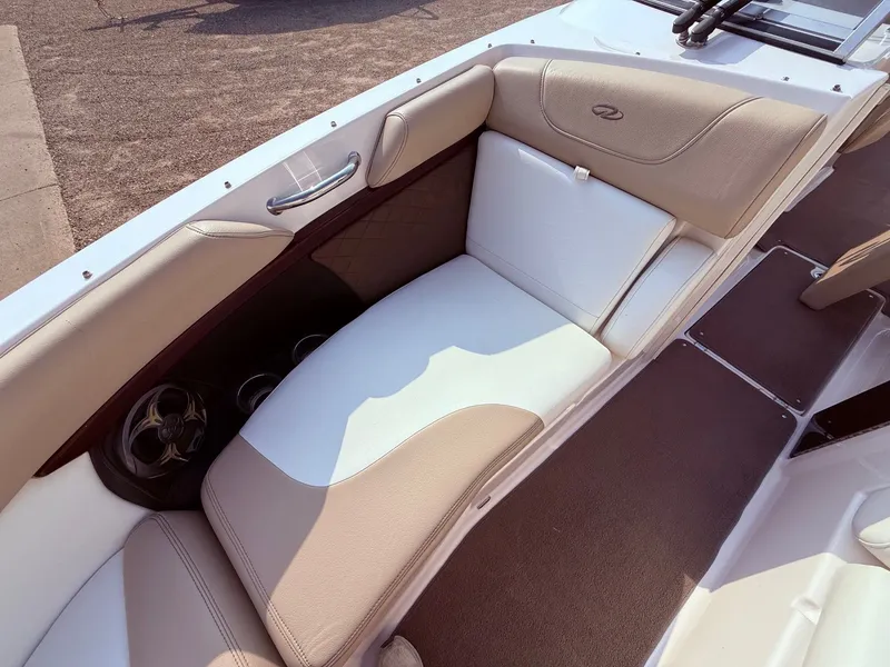 Slide: The Image of 2012 Regal 2700 Bowrider interior with beige and white seating, cup holders, and speaker. - 12