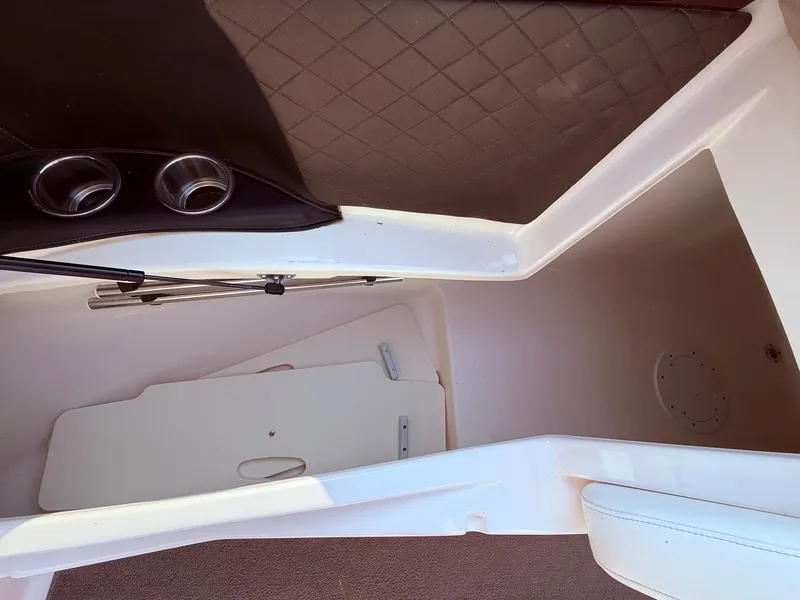 Slide: The Image of 2012 Regal 2700 Bowrider interior storage compartment with cup holders and cushioned seating. - 14
