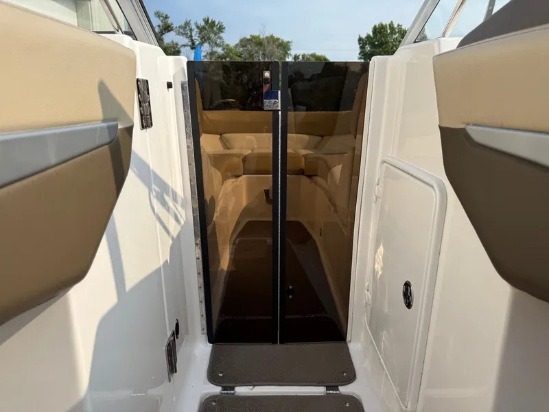 Slide: The Image of 2012 Regal 2700 Bowrider interior with glass door and beige seating. - 17