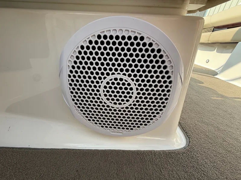 Slide: The Image of Speaker on 2012 Regal 2700 Bowrider boat, featuring white grille and carpeted flooring. - 24