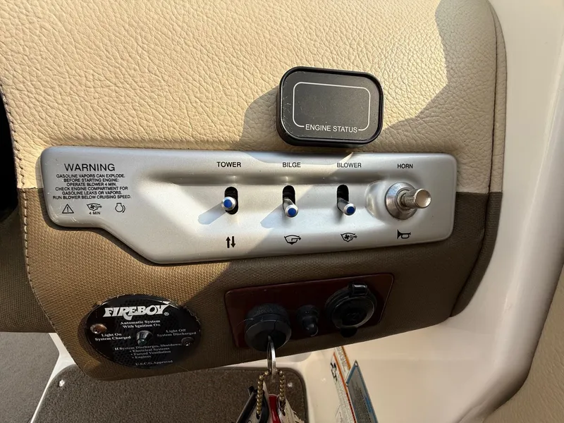 Slide: The Image of Control panel of a 2012 Regal 2700 Bowrider boat with switches and warning labels. - 25