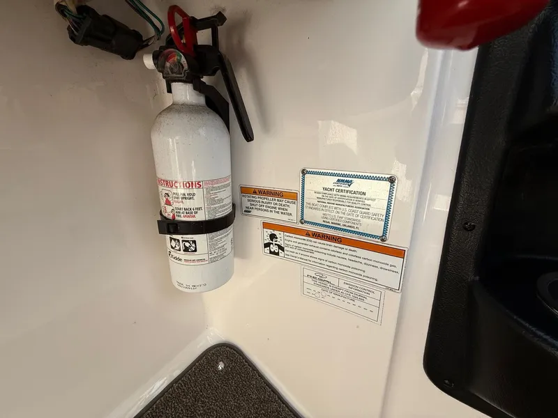 Slide: The Image of Fire extinguisher and safety labels on 2012 Regal 2700 Bowrider boat interior. - 27