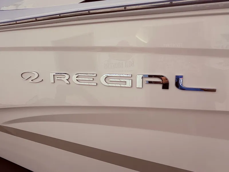 Slide: The Image of 2012 Regal 2700 Bowrider boat logo on white hull. - 4