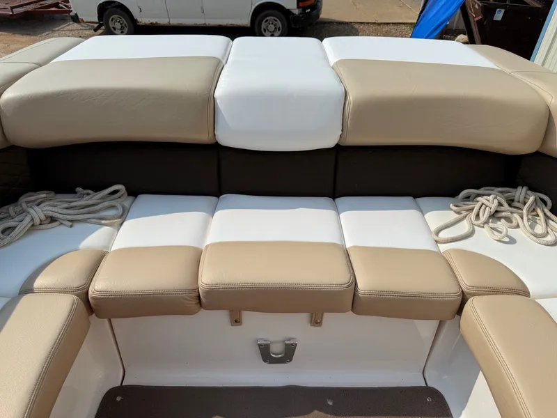 Slide: The Image of 2012 Regal 2700 Bowrider boat interior with beige and white seating, featuring coiled ropes. - 40