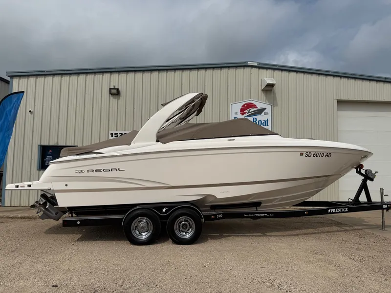 Slide: The Image of 2012 Regal 2700 Bowrider boat on trailer, parked outside a building. - 44