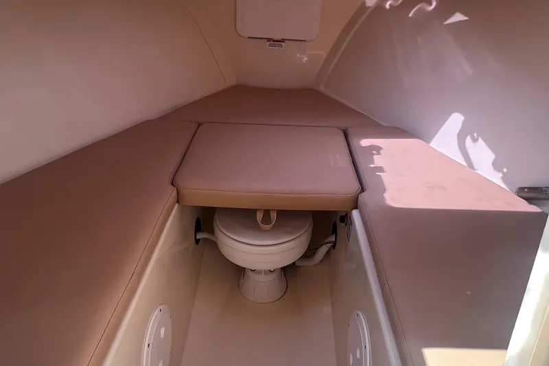 Slide: The Image of 2018 Rossiter 23 boat interior with cushioned seating and compact toilet. - 21