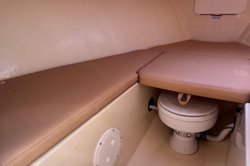 Slide: The Image of 2018 Rossiter 23 boat interior with cushioned seating and compact toilet. - 22