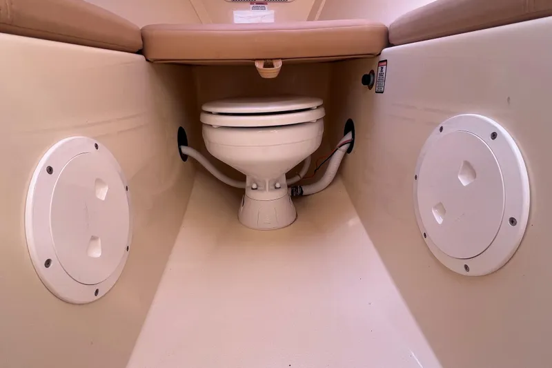 Slide: The Image of 2018 Rossiter 23 boat interior with marine toilet and storage compartments. - 23