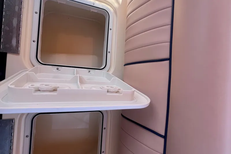 Slide: The Image of Interior of a 2018 Rossiter 23 boat, featuring storage compartments and cushioned seating. - 24