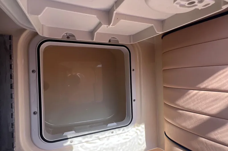 Slide: The Image of Interior view of a 2018 Rossiter 23 boat, featuring a storage compartment and cushioned seating. - 25