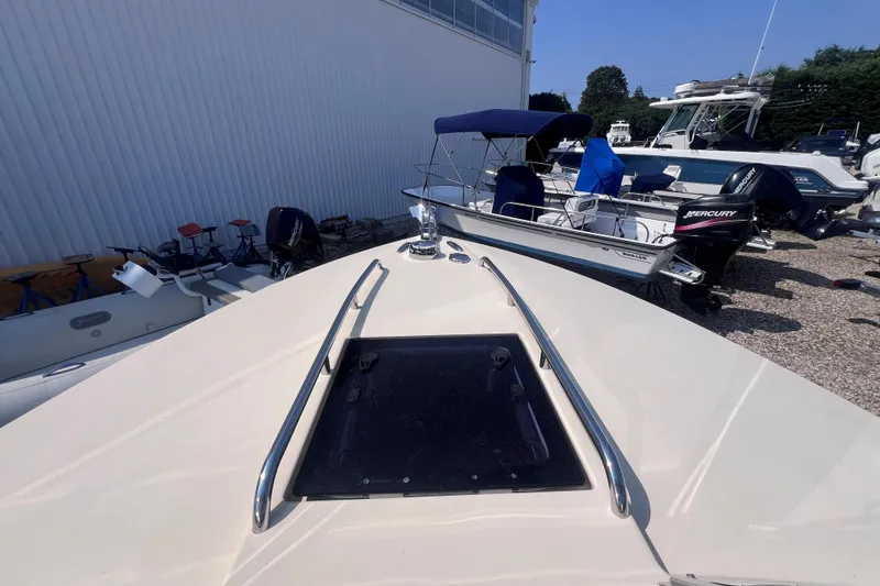 Slide: The Image of 2018 Rossiter 23 boat docked, surrounded by other boats and equipment. - 26