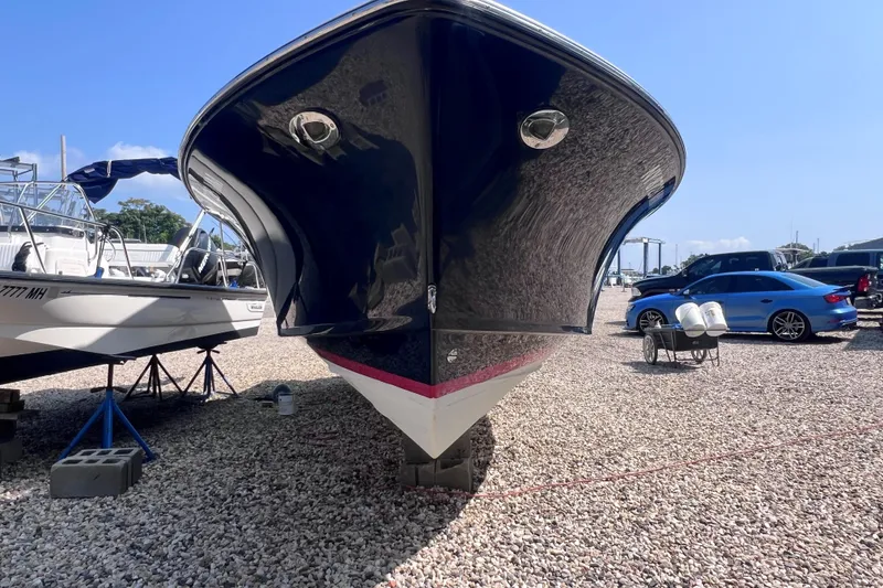 Slide: The Image of 2018 Rossiter 23 boat on gravel lot, alongside other vehicles and boats. - 28