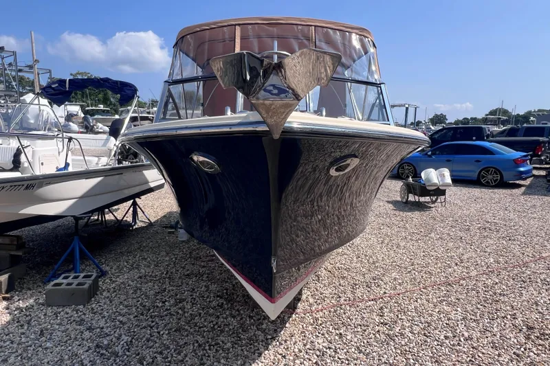 Slide: The Image of 2018 Rossiter 23 boat on gravel lot, surrounded by other vehicles and boats. - 29