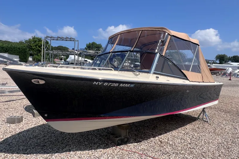 Slide: The Image of 2018 Rossiter 23 boat with tan canopy, parked on gravel under a clear blue sky. - 30