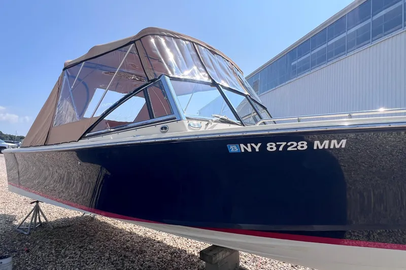 Slide: The Image of 2018 Rossiter 23 boat with canopy, parked on gravel near a building. - 32