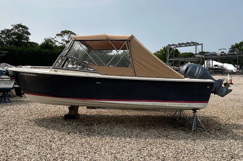 Slide: The Image of 2018 Rossiter 23 boat with tan canopy on gravel lot. - 34