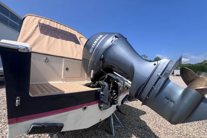 Slide: The Image of 2018 Rossiter 23 boat with Yamaha outboard motor, parked on gravel under clear blue sky. - 4