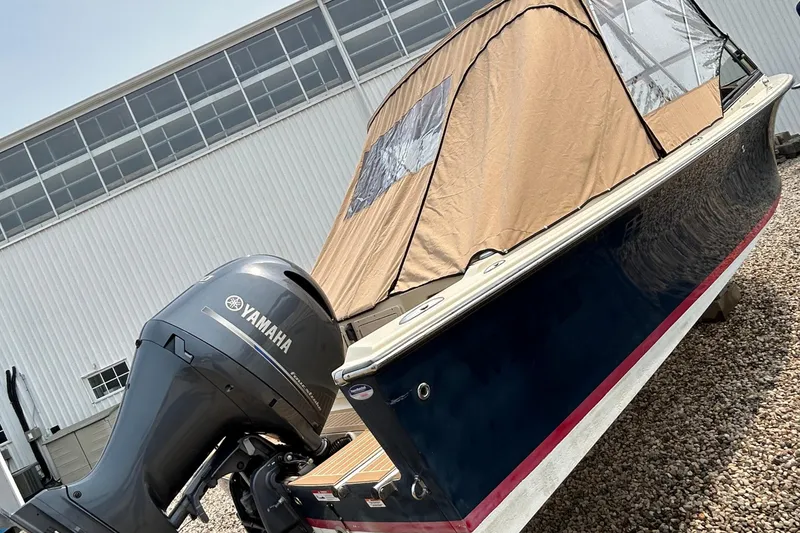 Slide: The Image of 2018 Rossiter 23 boat with Yamaha outboard motor, covered and parked on gravel. - 5