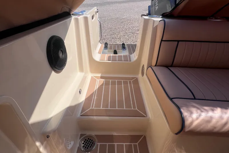 Slide: The Image of 2018 Rossiter 23 boat interior with cushioned seating and speaker. - 6