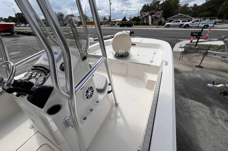 Slide: The Image of 2024 Carolina Skiff 21 LS boat interior with console and seating, parked near a road. - 11