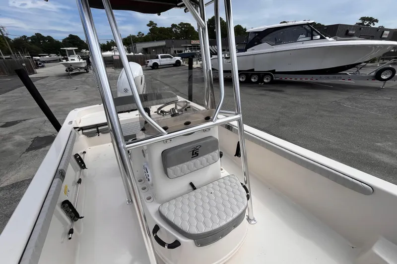 Slide: The Image of 2024 Carolina Skiff 21 LS boat interior with seating and console, parked in a marina. - 15