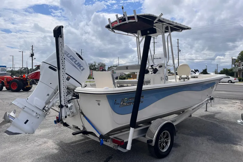 Slide: The Image of 2024 Carolina Skiff 21 LS boat with Suzuki outboard motor on trailer, parked outdoors. - 4