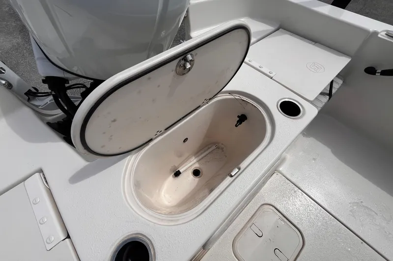 Slide: The Image of 2024 Carolina Skiff 21 LS boat with open storage compartment and motor detail. - 7