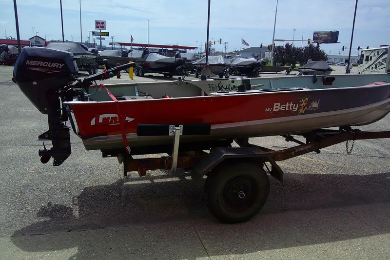 Slide: The Image of 1965 Lund V14 boat on trailer with Mercury outboard motor in parking lot. - 5