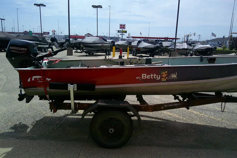 Slide: The Image of 1965 Lund V14 boat with Mercury motor on trailer, parked in a lot. - 6