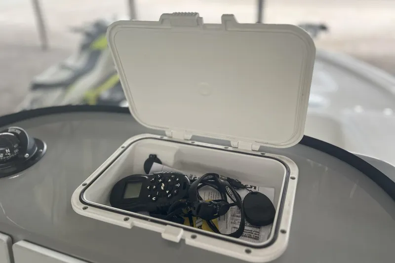 Slide: The Image of Open storage compartment on 2023 Sea Pro 248 Bay boat with electronic devices inside. - 5