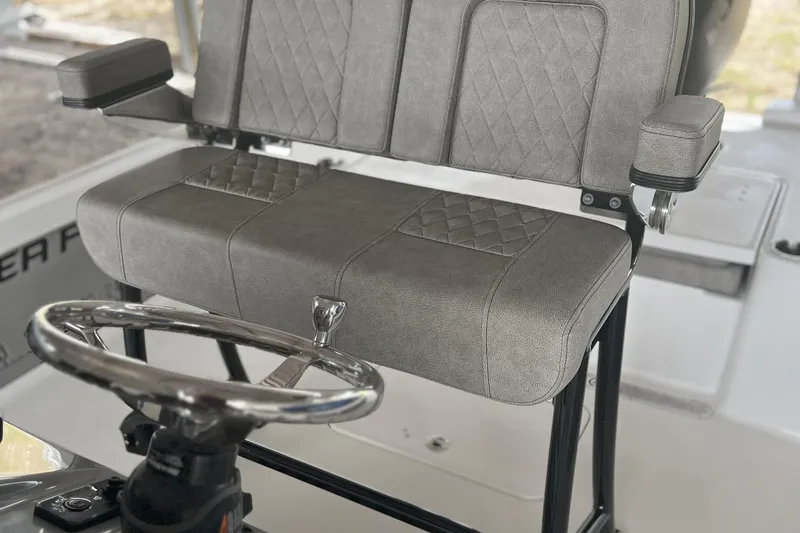 Slide: The Image of 2023 Sea Pro 248 Bay boat seat with diamond-stitched upholstery and steering wheel. - 6