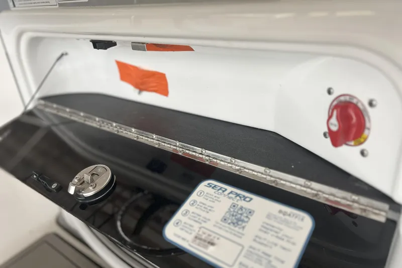 Slide: The Image of 2023 Sea Pro 248 Bay boat compartment with control panel and safety instructions. - 7