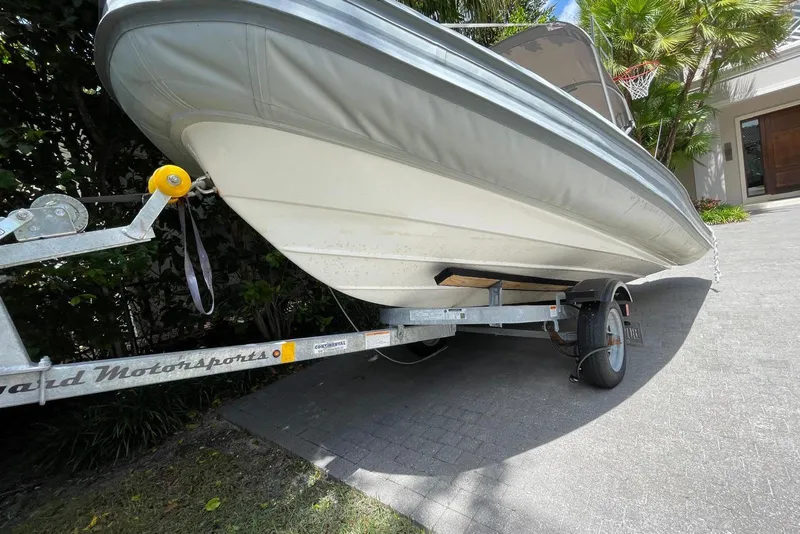 Slide: The Image of 2024 Flexboat Flex 450 on trailer, parked in driveway, surrounded by greenery. - 11