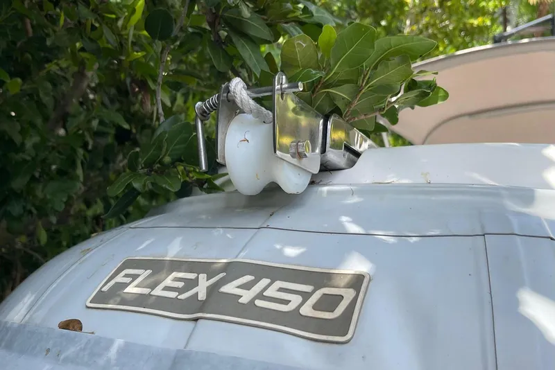 Slide: The Image of Flexboat Flex 450 with foliage, showcasing its durable design amidst greenery. - 17