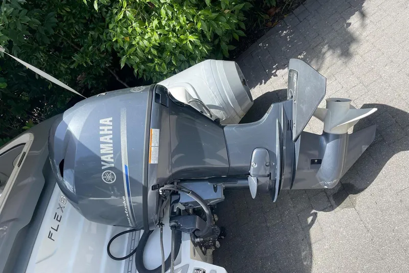 Slide: The Image of Outboard Yamaha engine on a Flexboat Flex 450, parked on a paved surface. - 3
