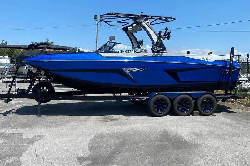 The Image of 2023 Tigé 24RZX boat in vibrant blue on a trailer, parked outdoors. - 0