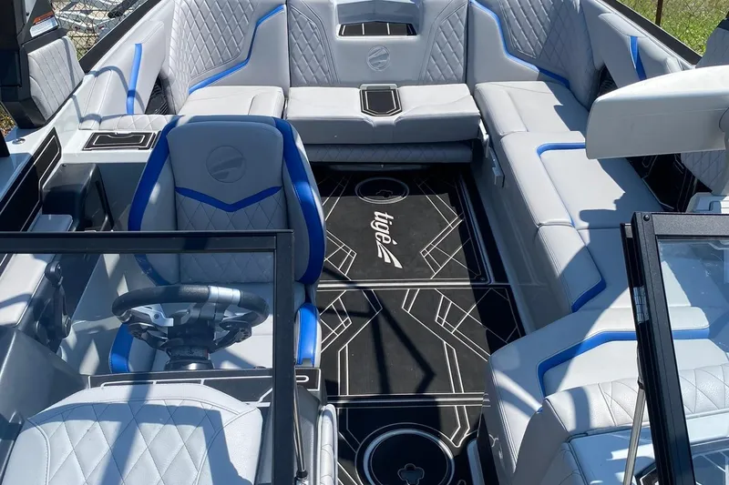 Slide: The Image of 2023 Tigé 24RZX boat interior with luxurious seating and modern steering wheel design. - 11