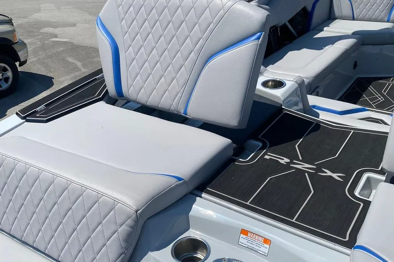 Slide: The Image of 2023 Tigé 24RZX boat interior with gray and blue seating, RZX branding. - 16