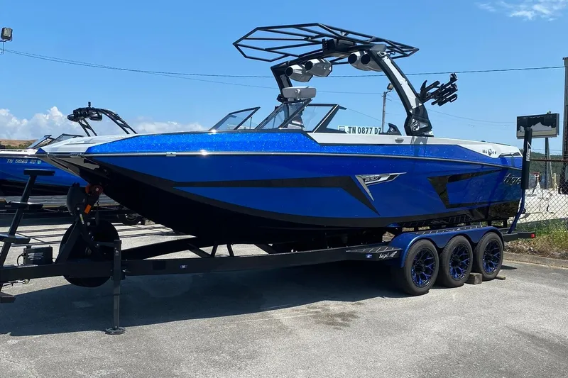 Slide: The Image of 2023 Tigé 24RZX boat in vibrant blue on a trailer, parked outdoors. - 20