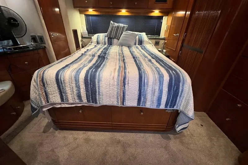 Slide: The Image of Interior of 2000 Carver 506 Motor Yacht bedroom with striped bedding and wooden cabinetry. - 21