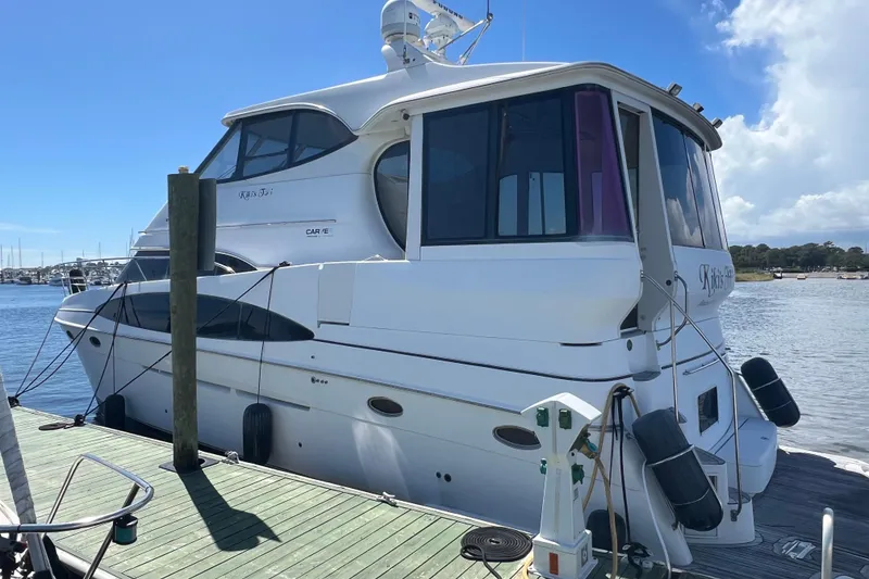 Slide: The Image of 2000 Carver 506 Motor Yacht docked, showcasing sleek design and spacious deck. - 44