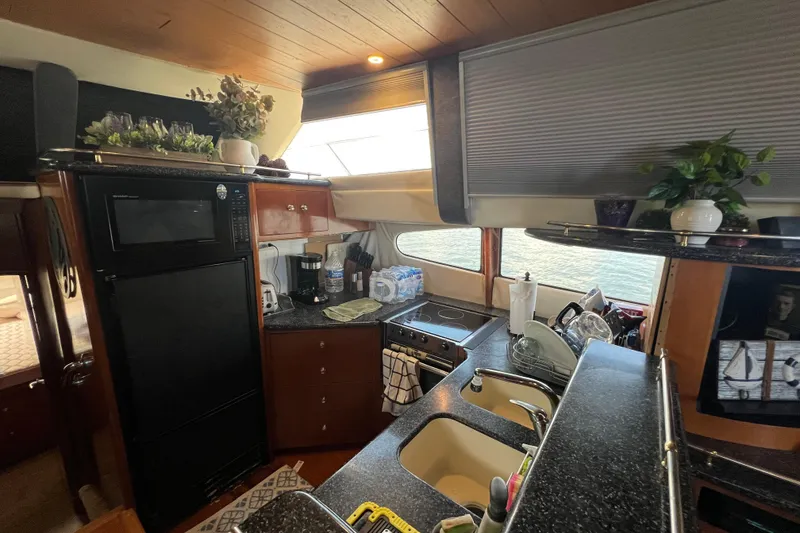 Slide: The Image of 2000 Carver 506 Motor Yacht docked at a marina under a partly cloudy sky. - 55