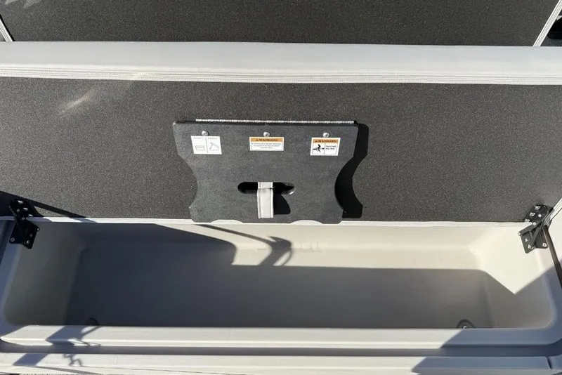 Slide: The Image of Open storage compartment in a 2025 Barletta A20UC boat, featuring a secure latch system. - 22