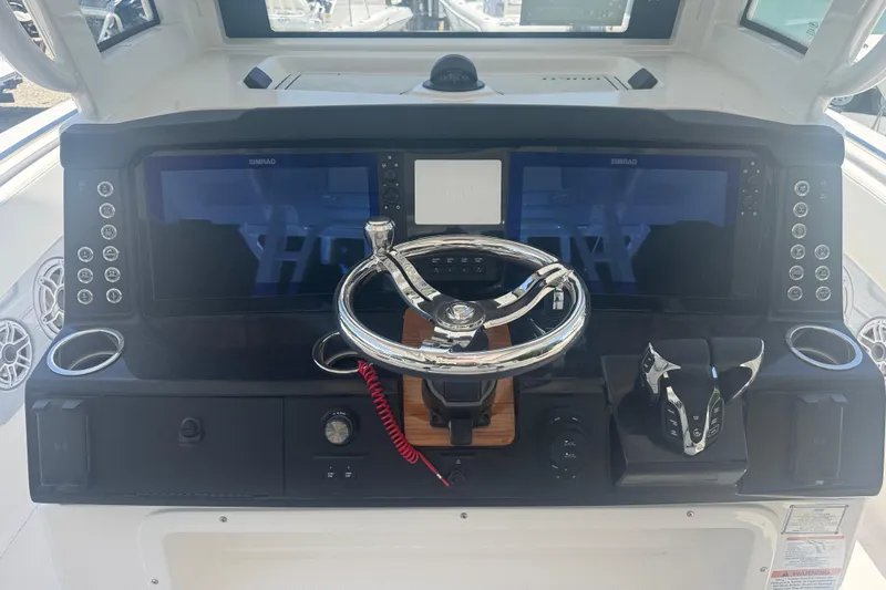 Slide: The Image of 2025 Robalo R300 Center Console dashboard with steering wheel and dual displays. - 12
