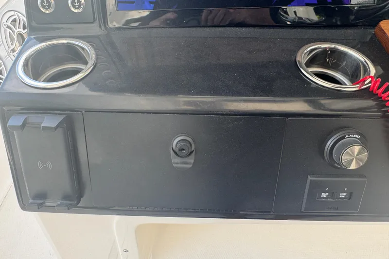 Slide: The Image of 2025 Robalo R300 Center Console dashboard with cup holders and audio controls. - 16