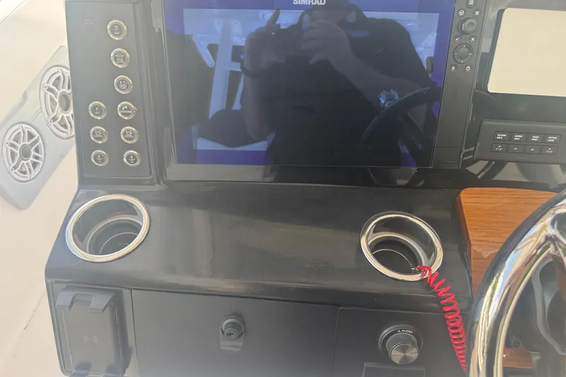 Slide: The Image of Control panel of 2025 Robalo R300 Center Console boat with steering wheel and electronics. - 18