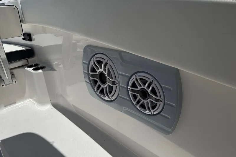 Slide: The Image of 2025 Robalo R300 Center Console boat interior with dual speakers and cup holder. - 23