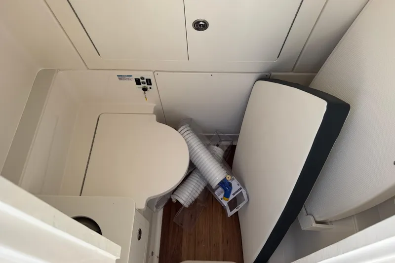 Slide: The Image of 2025 Robalo R300 Center Console interior with compact toilet and storage space. - 29