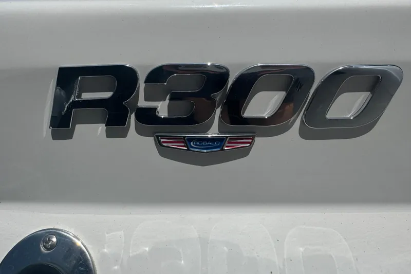 Slide: The Image of 2025 Robalo R300 Center Console boat emblem on white surface. - 3