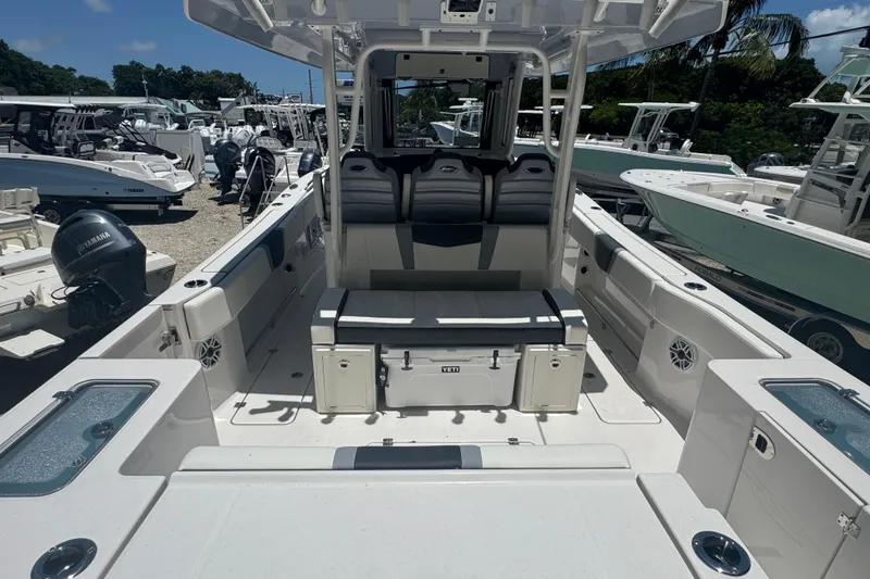 Slide: The Image of 2025 Robalo R300 Center Console boat interior with seating and storage, docked among other boats. - 4